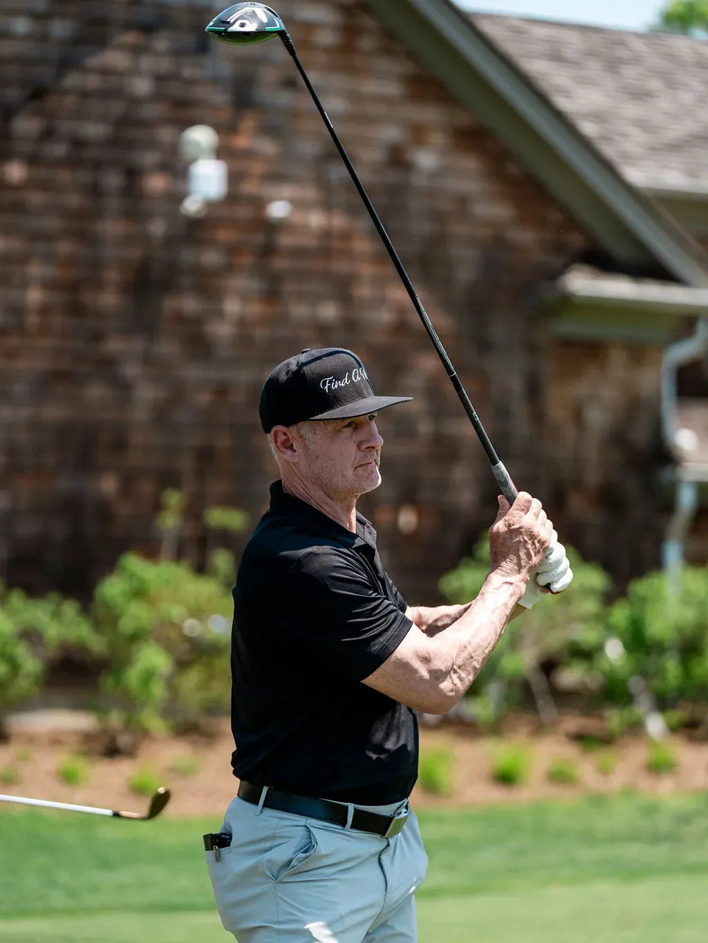 A golfer mid-swing at the Blue & Gold Classic